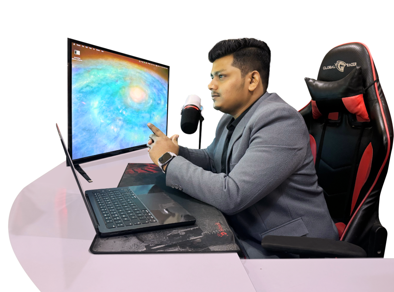 Home 14 Ashar Malik working at his desk with a laptop, monitor, and microphone, focused on his work